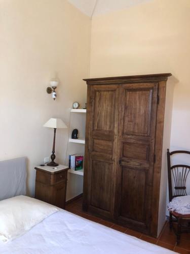 a bedroom with a wooden cabinet next to a bed at A Loghja Di Cavallo Morto in Bonifacio