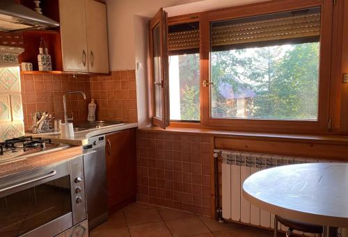 a kitchen with a sink and a window and a table at domek w wsi Ząb in Ząb