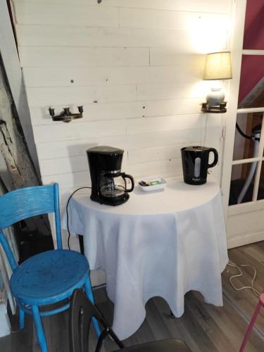 a table with two pitchers on it with two chairs at Hôtellerie Jardiniers Gourmands in Morsains