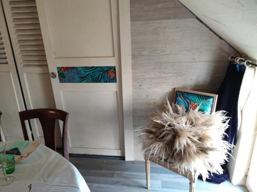 a room with a door and a chair with a feather at Hôtellerie Jardiniers Gourmands in Morsains