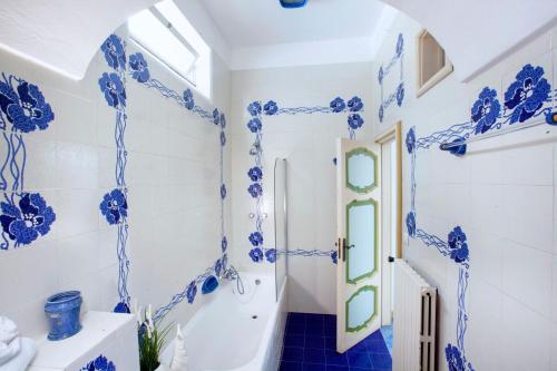 ein blau-weißes Bad mit einer Badewanne und einem Waschbecken in der Unterkunft Estate4home- La casa del Maresciallo in Positano