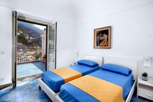 two beds in a room with a balcony at Estate4home- La casa del Maresciallo in Positano
