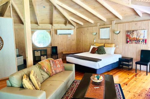 a bedroom with a bed and a couch in a room at Grampians Chalets in Halls Gap