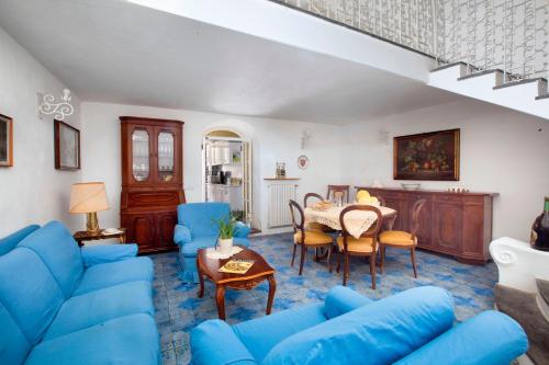 a living room with a blue couch and a table at Estate4home- La casa del Maresciallo in Positano