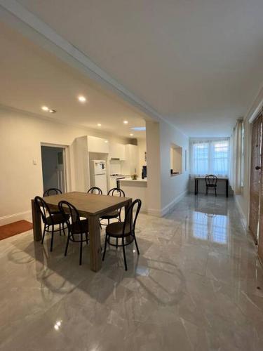 a dining room with a table and chairs and a kitchen at Close to CBD Renovated Cottage in Prospect