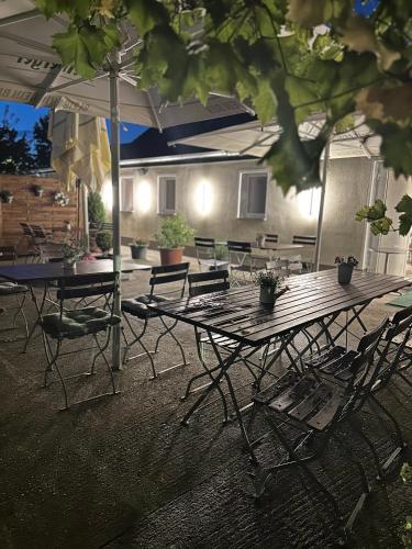 a patio with tables and chairs and an umbrella at Gasthaus Am Colphus in Barby