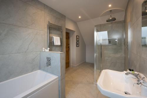 a bathroom with a tub and a shower and a sink at Kipney Hunting Lodge in Perth