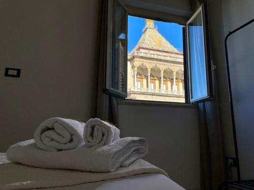 Blick auf ein Gebäude aus einem Fenster mit Handtüchern in der Unterkunft La Porta dei Mori in Palermo