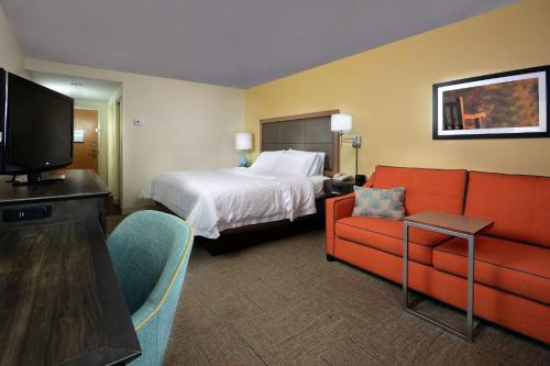a hotel room with a bed and a couch at Hampton Inn Martinsville in Martinsville