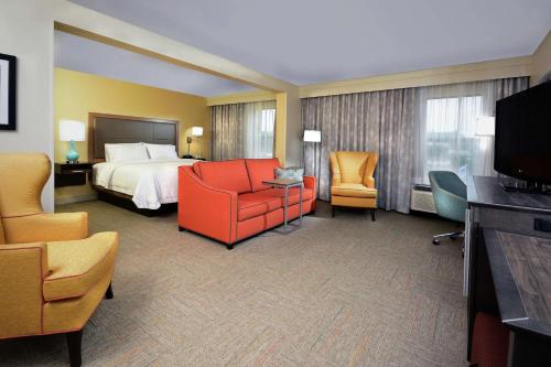a hotel room with a bed and chairs and a television at Hampton Inn Martinsville in Martinsville