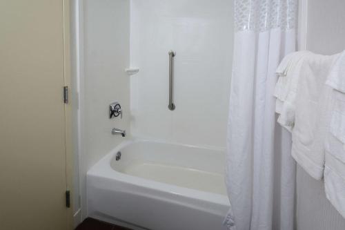 a white bath tub with a shower curtain in a bathroom at Hampton Inn Martinsville in Martinsville