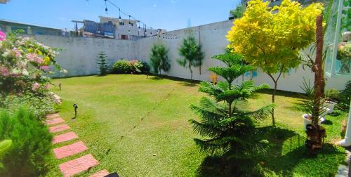 un patio con una valla y un césped con un árbol en Santa Cruz Garden, en Tacloban