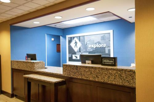 an office lobby with a blue wall and a reception counter at Hampton Inn Metairie in Metairie