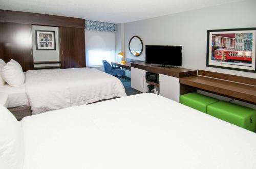 a hotel room with two beds and a flat screen tv at Hampton Inn Metairie in Metairie