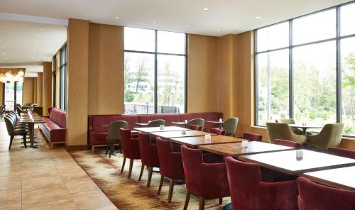 a restaurant with tables and chairs and large windows at Hilton Garden Inn Boston/Marlborough in Marlborough
