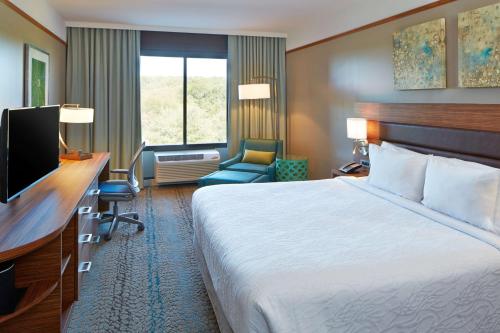 Habitación de hotel con cama, escritorio y TV. en Hilton Garden Inn Boston/Marlborough, en Marlborough