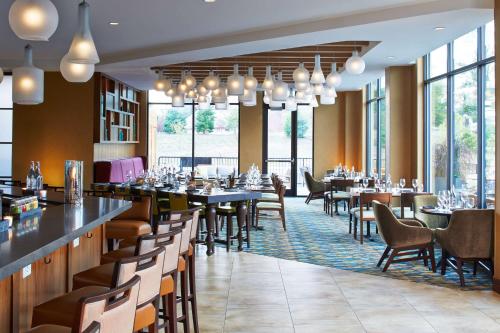 un restaurant avec des tables, des chaises et des fenêtres dans l'établissement Hilton Garden Inn Boston/Marlborough, à Marlborough