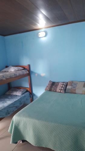 a bedroom with two bunk beds and a blue wall at CASA DE TEMPORADA RECANTO FELIz 2 in Aracaju