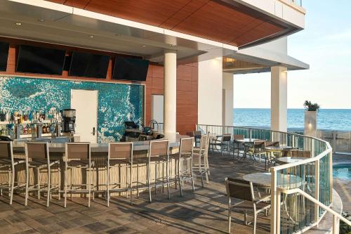 a restaurant on the beach with chairs and a bar at Hilton Grand Vacations Club Ocean Enclave Myrtle Beach in Myrtle Beach