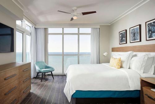 a bedroom with a large bed and a large window at Hilton Grand Vacations Club Ocean Enclave Myrtle Beach in Myrtle Beach