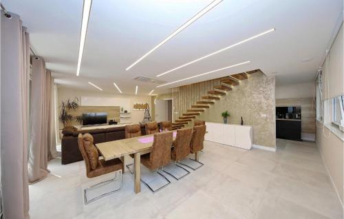 a dining room with a table and chairs and a staircase at Villa Mara in Zaton