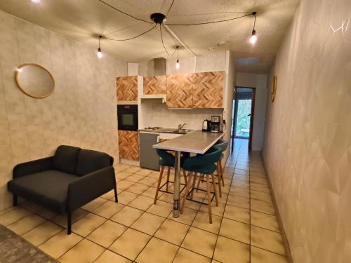 a kitchen and living room with a table and chairs at le Moulin des Moines in Châtenois