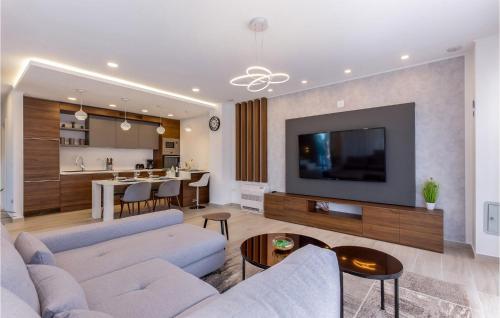 ein Wohnzimmer mit einem Sofa und einem TV sowie eine Küche in der Unterkunft Villa Maestral in Zaton