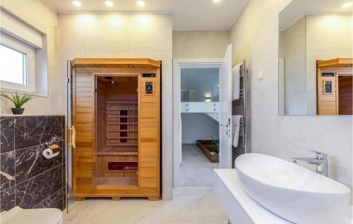 ein Badezimmer mit Waschbecken, Toilette und Spiegel in der Unterkunft Villa Maestral in Zaton
