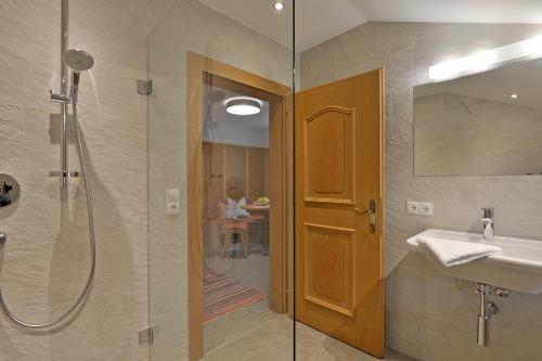 a bathroom with a shower and a sink and a mirror at Bergchalet Emberg in Aschau