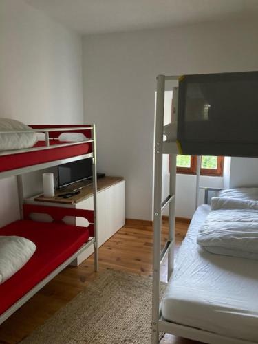 a dorm room with two bunk beds and a television at Maison en pierre dans le Sidobre in Le Bez