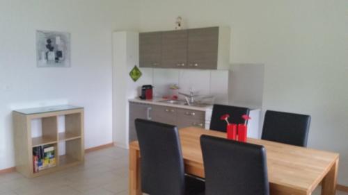 a kitchen with a wooden table and black chairs at Ferienhaus Stockli in Brunnen