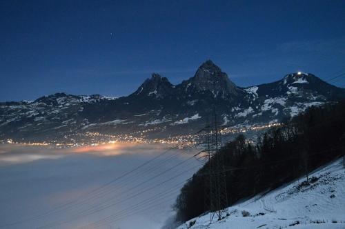 a snow covered mountain with a city in the distance at Ferienhaus Stockli in Brunnen
