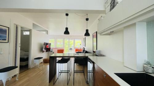 a kitchen with white walls and a island with bar stools at ApartmentInCopenhagen Apartment 139 in Copenhagen