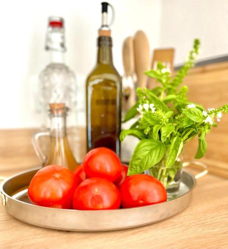 a bowl of tomatoes on a table with a bottle of wine at Bungalow for 2 - Dream Oasis Dobra Voda in Dobra Voda