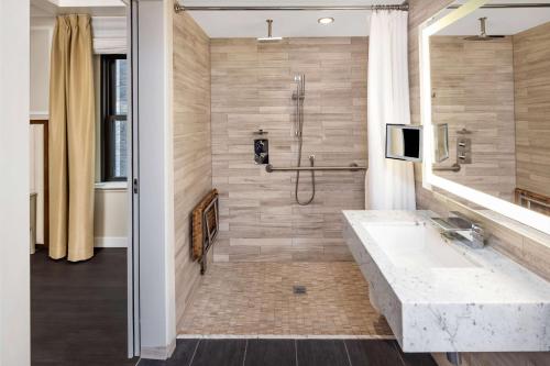 a bathroom with a large sink and a shower at Hilton Club The Quin New York in New York