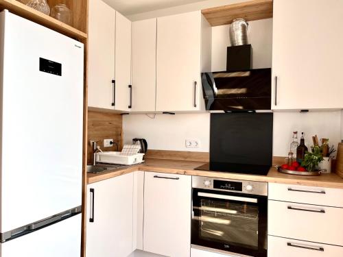 a kitchen with white cabinets and a microwave at Bungalow Dream Oasis Dobra Voda in Dobra Voda