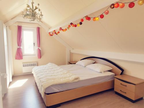 a bedroom with a bed with christmas decorations on the ceiling at Izzy's Rainbow House in De Haan