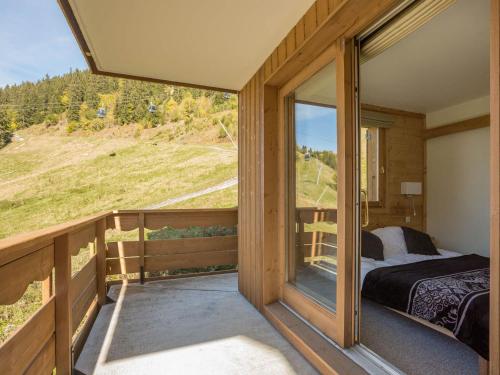 - une chambre avec un lit et une fenêtre sur un balcon dans l'établissement Charmant duplex 4 pièces, 7 pers, Méribel, pied des pistes, balcon, garage, WiFi - FR-1-411-511, à Les Allues