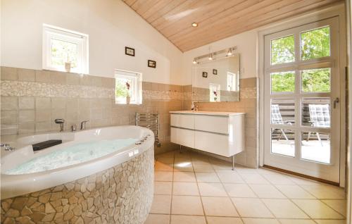 ein großes Bad mit einer Badewanne und einem Waschbecken in der Unterkunft 4 Bedroom Gorgeous Home In Glesborg in Fjellerup