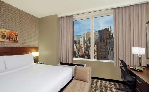 Habitación de hotel con cama y ventana grande en Hilton Garden Inn New York/Midtown Park Avenue, en Nueva York