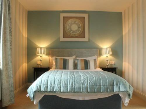 a bedroom with a bed with two lamps on either side at The Keep Boutique Hotel in Yeovil