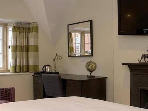 a bedroom with a desk and a mirror and a bed at The Keep Boutique Hotel in Yeovil
