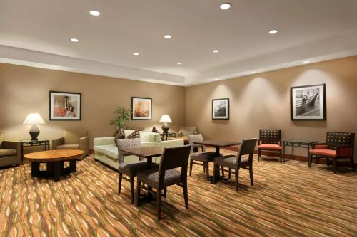 a hotel lobby with tables and chairs and a couch at Hampton Inn New York - LaGuardia Airport in Queens
