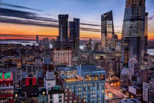 une ligne d'horizon de la ville au coucher du soleil avec de grands bâtiments dans l'établissement Doubletree By Hilton New York Times Square West, à New York
