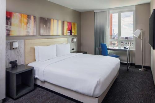 a hotel room with a large white bed and a desk at Doubletree By Hilton New York Times Square West in New York