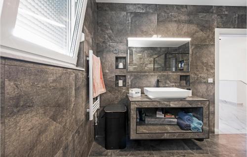 ein Bad mit einem Waschbecken und einem Spiegel in der Unterkunft Nice Home In Bilice With Outdoor Swimming Pool in Bilice