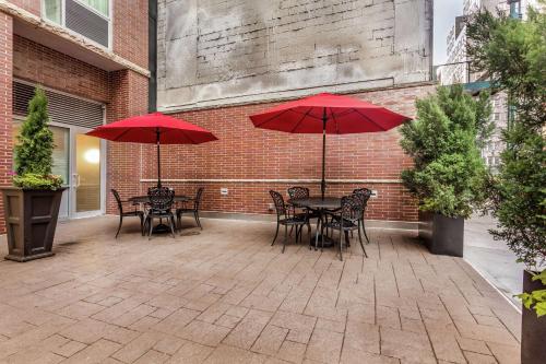 a patio with tables and chairs with red umbrellas at Hampton Inn Manhattan Grand Central in New York
