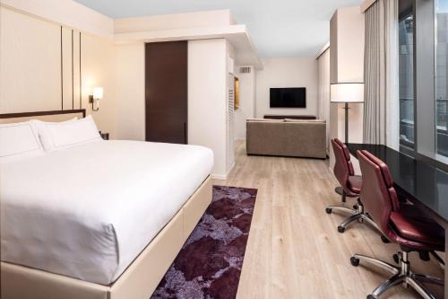 a hotel room with a bed and two chairs at Hilton Club West 57th Street New York in New York