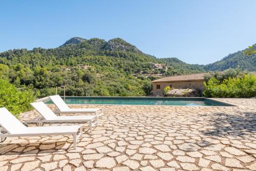 uma villa com uma piscina com montanhas ao fundo em Agroturismo Filicumis em Lloseta