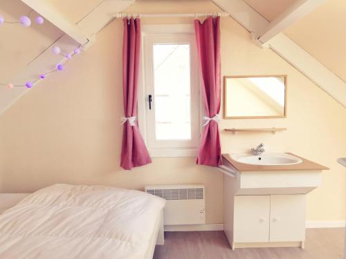 a bedroom with a bed and a sink and a window at Izzy's Rainbow House in De Haan